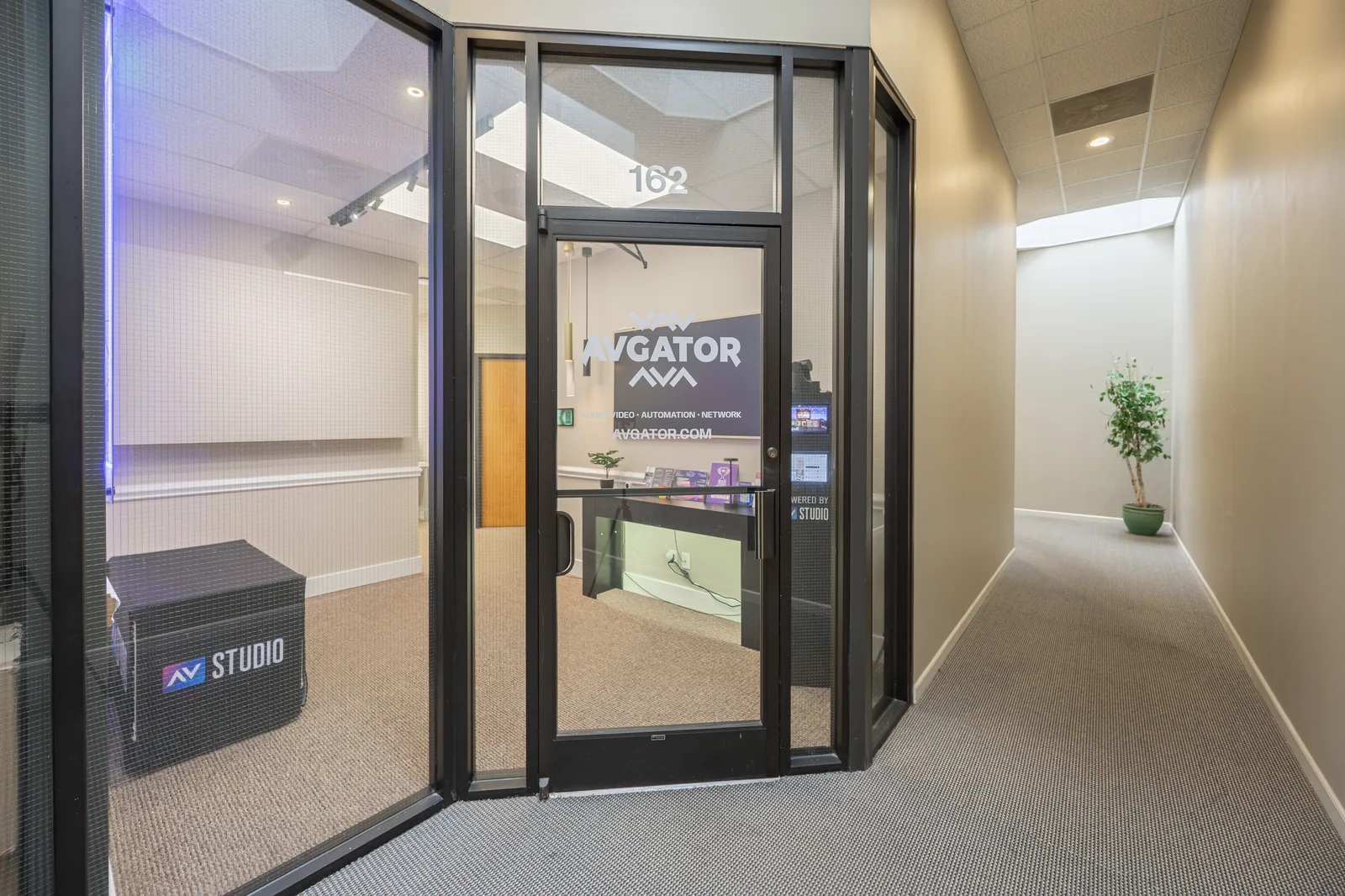 The glass entrance to the AVgator Charlotte showroom, Suite 162