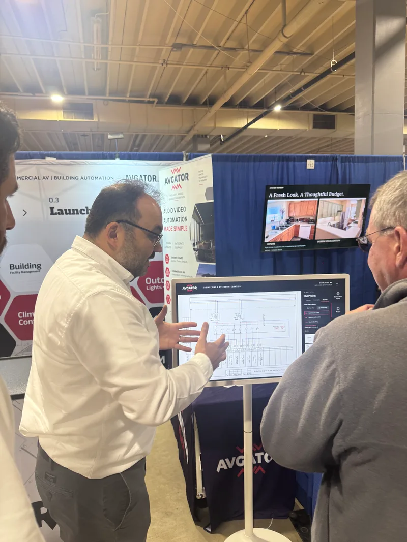 An AVgator team member using project drawings to explain the design and implementation process to a show visitor